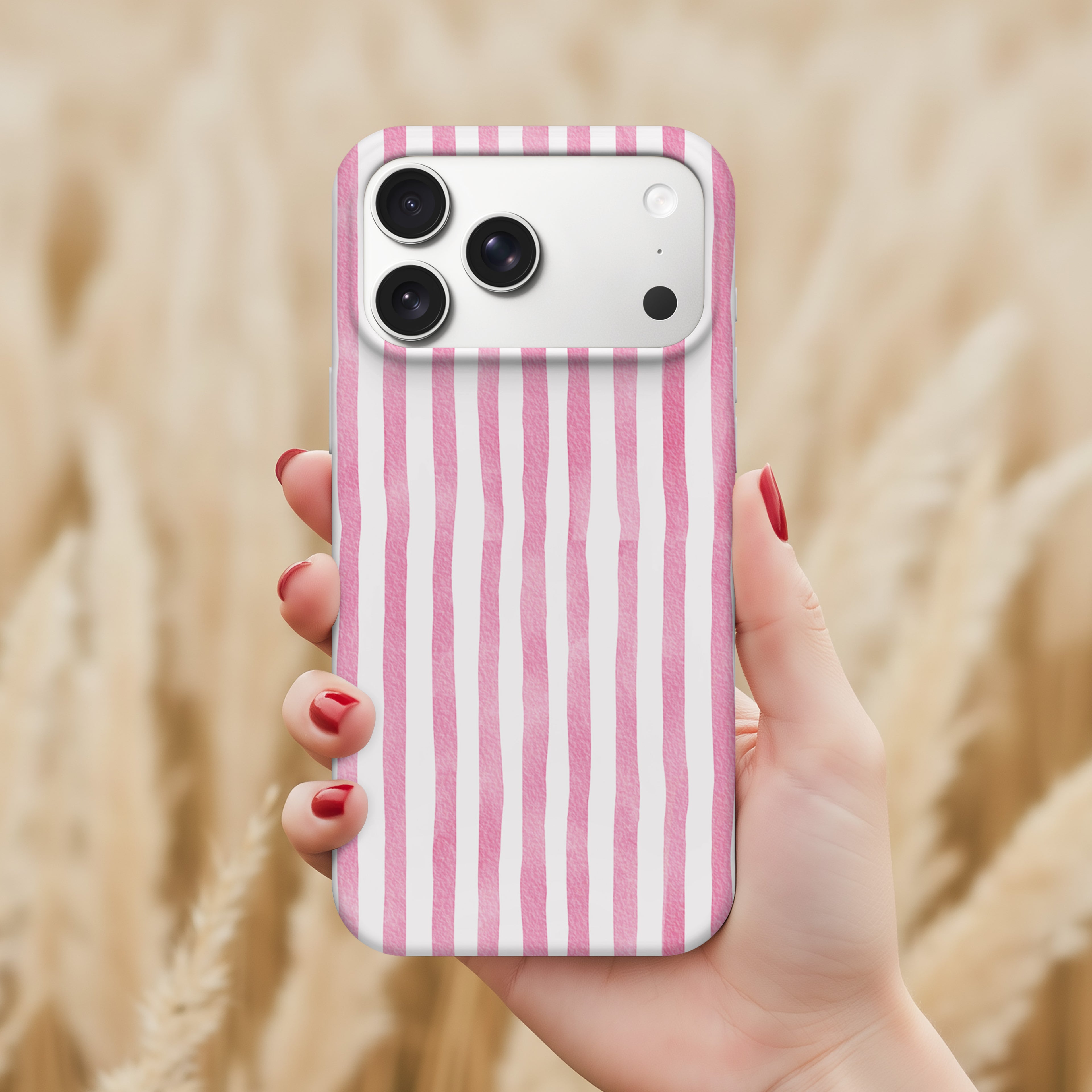 A hand holding a pink and white striped phone case with a camera on the back.