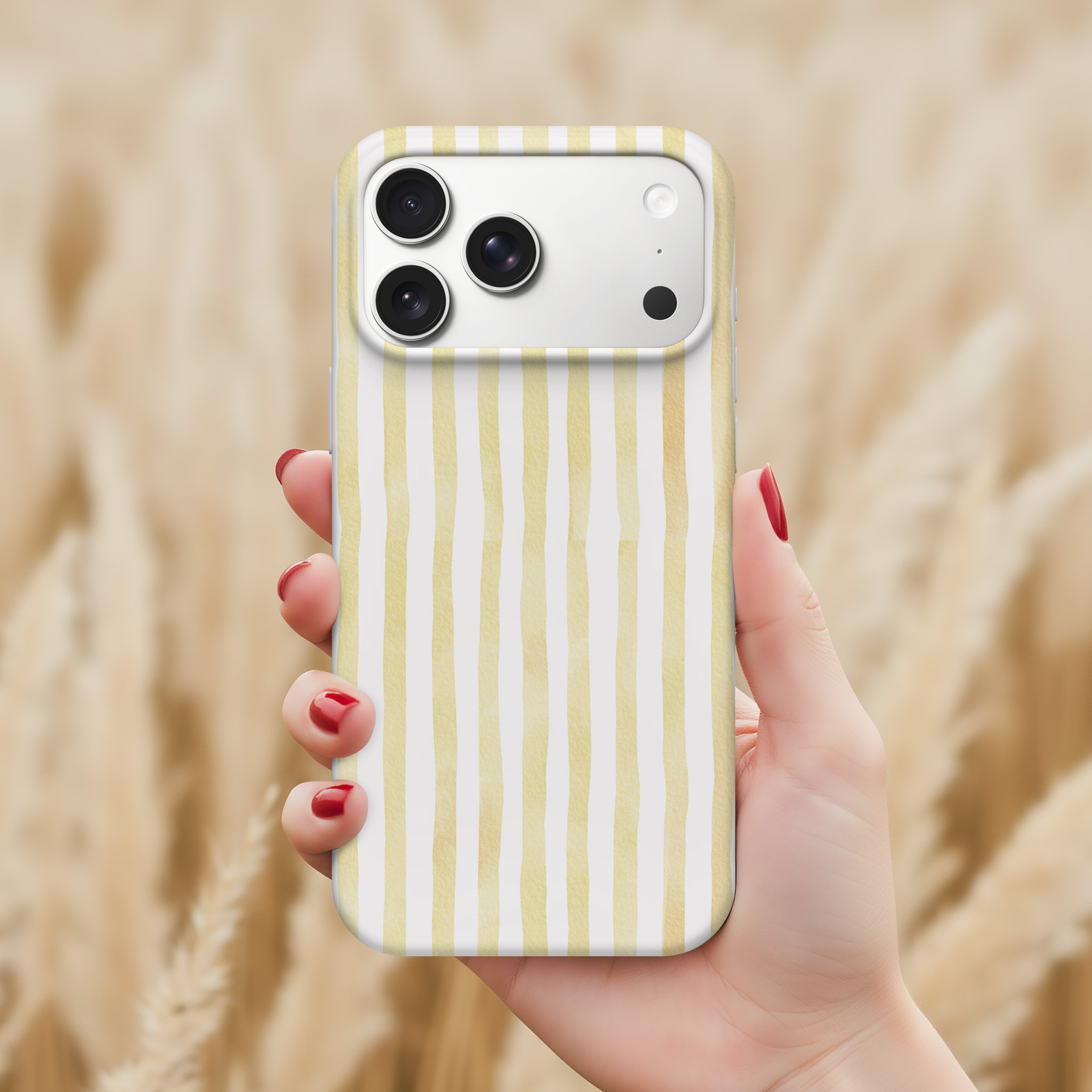 A hand holding a smartphone with a yellow and white striped pattern on the back cover.