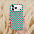 A hand holding a phone with a colorful checkered pattern on the back cover.