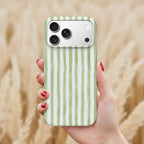 A hand holding a phone with a green and white striped pattern on the back cover.