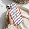 A person's hand holding a phone case with a striped pattern of orange and blue lobsters.