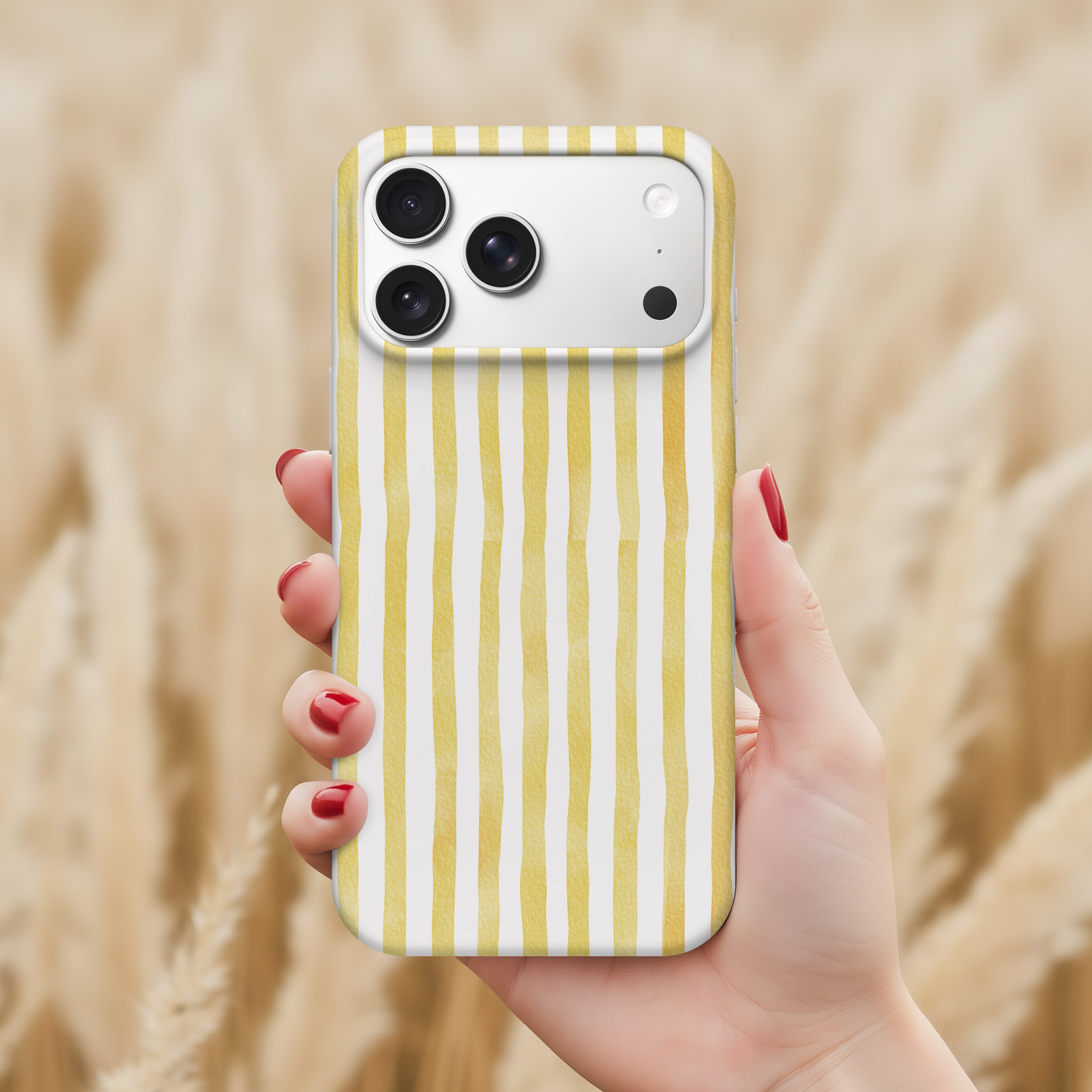 A hand holding a smartphone with a yellow and white striped pattern on the case.