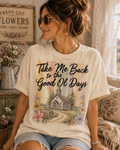 A woman wearing a t-shirt with a graphic design of a church and flowers, sitting in a room with a window and floral decorations.