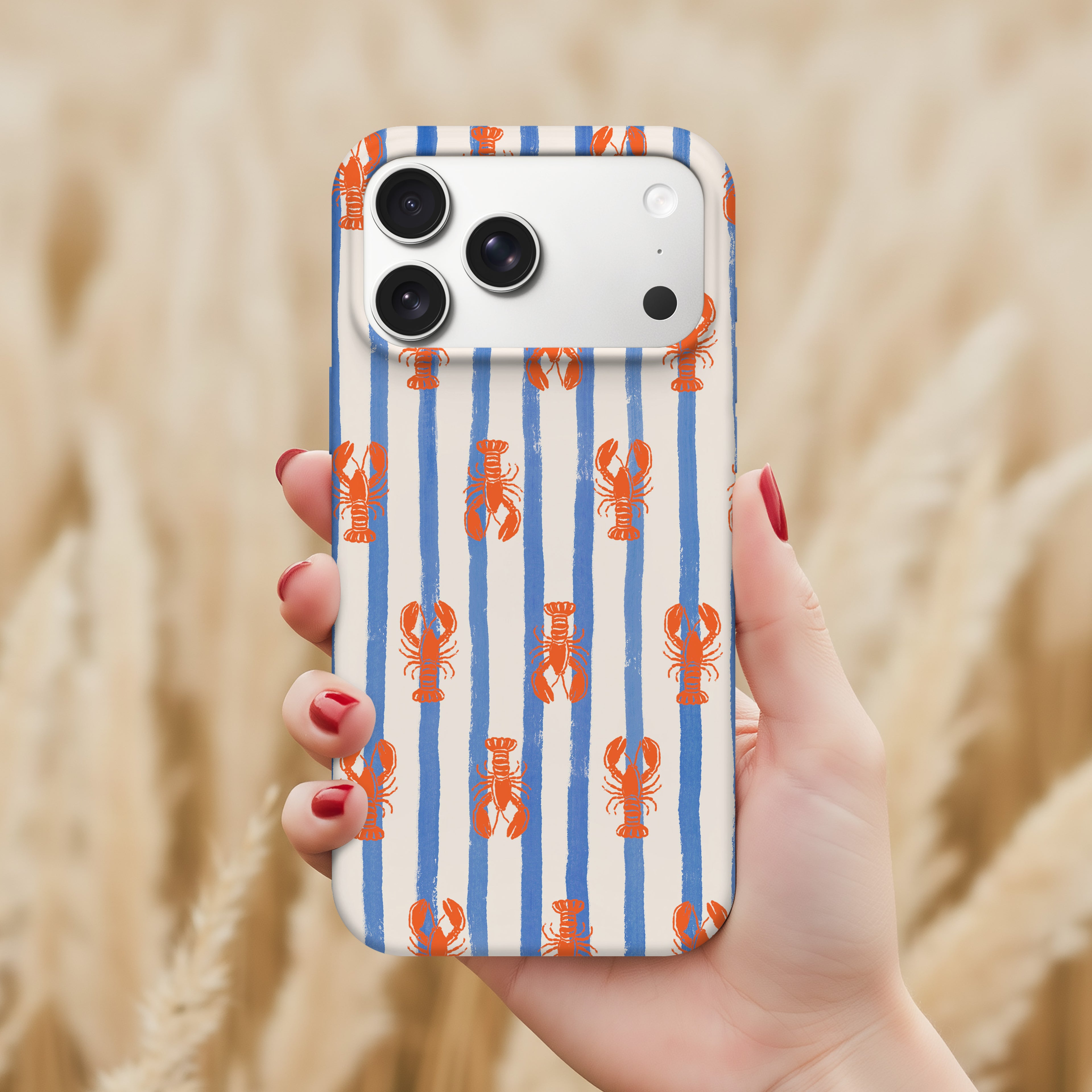 A hand holding a smartphone with a striped pattern of orange and blue lobsters on a white background.