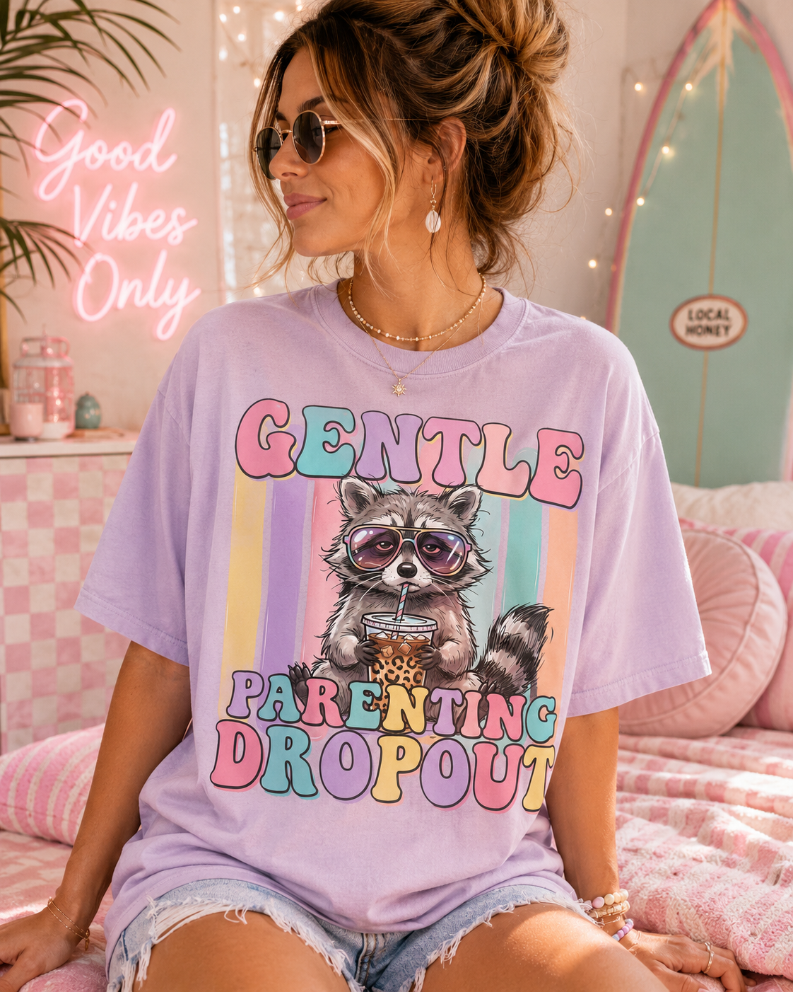 A woman wearing a purple t-shirt with a graphic of a raccoon and the text "Gentle PARENTING DROPOUT" is sitting on a bed.