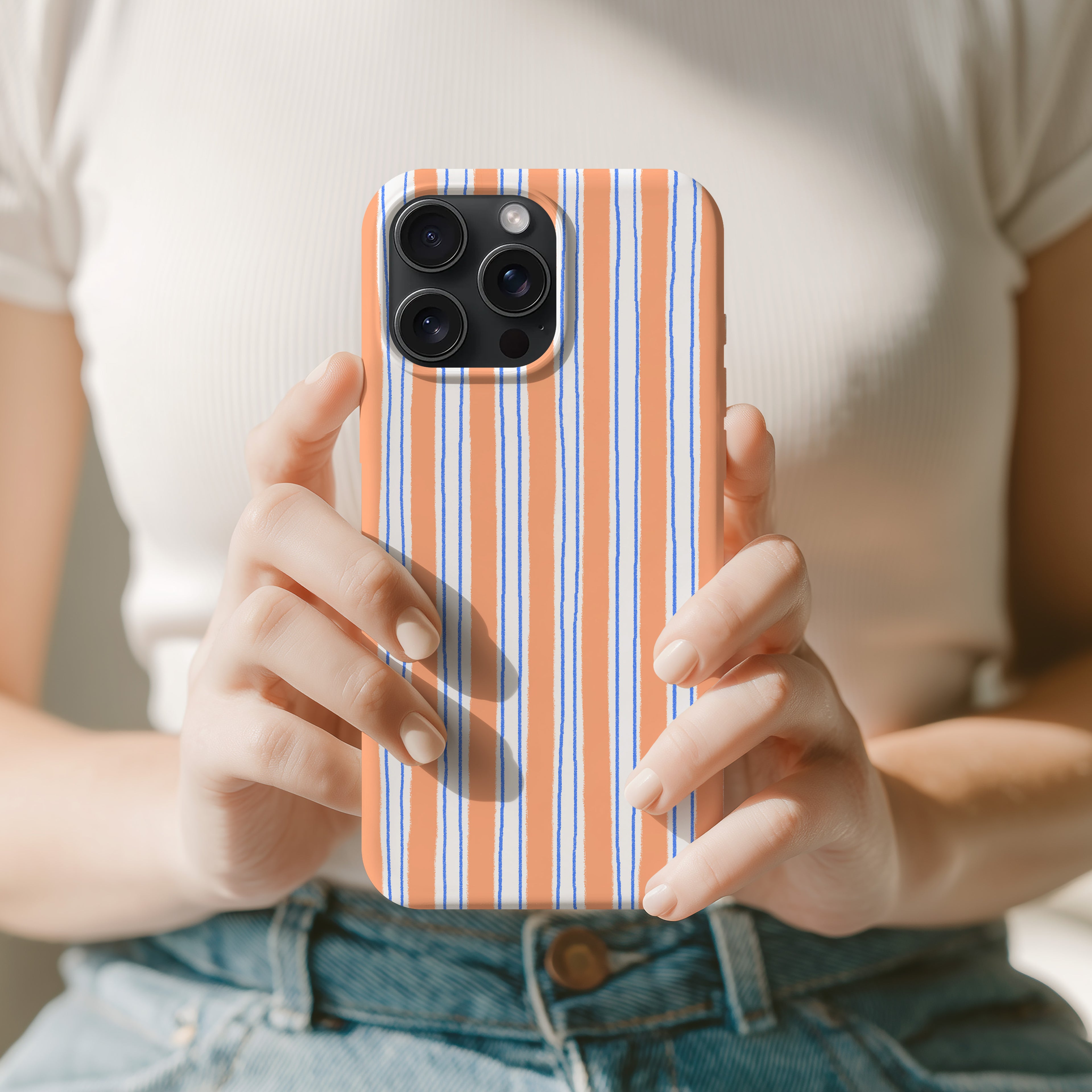 A person is holding a smartphone with a striped pattern on the case.